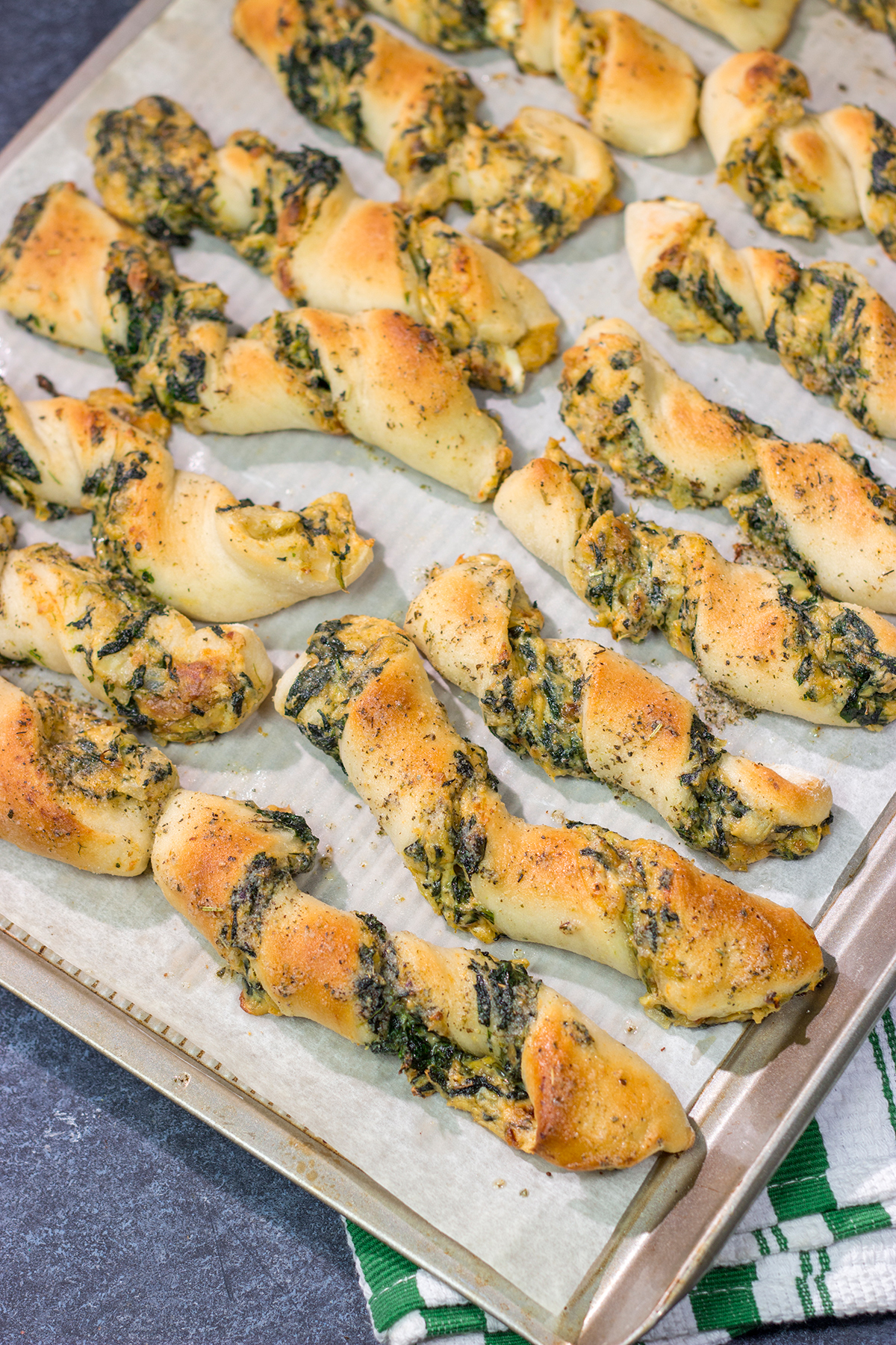 Looking for a tasty gameday appetizer? These Spinach Artichoke Breadsticks are a combination of garlic knots + spinach artichoke dip. They're delicious!