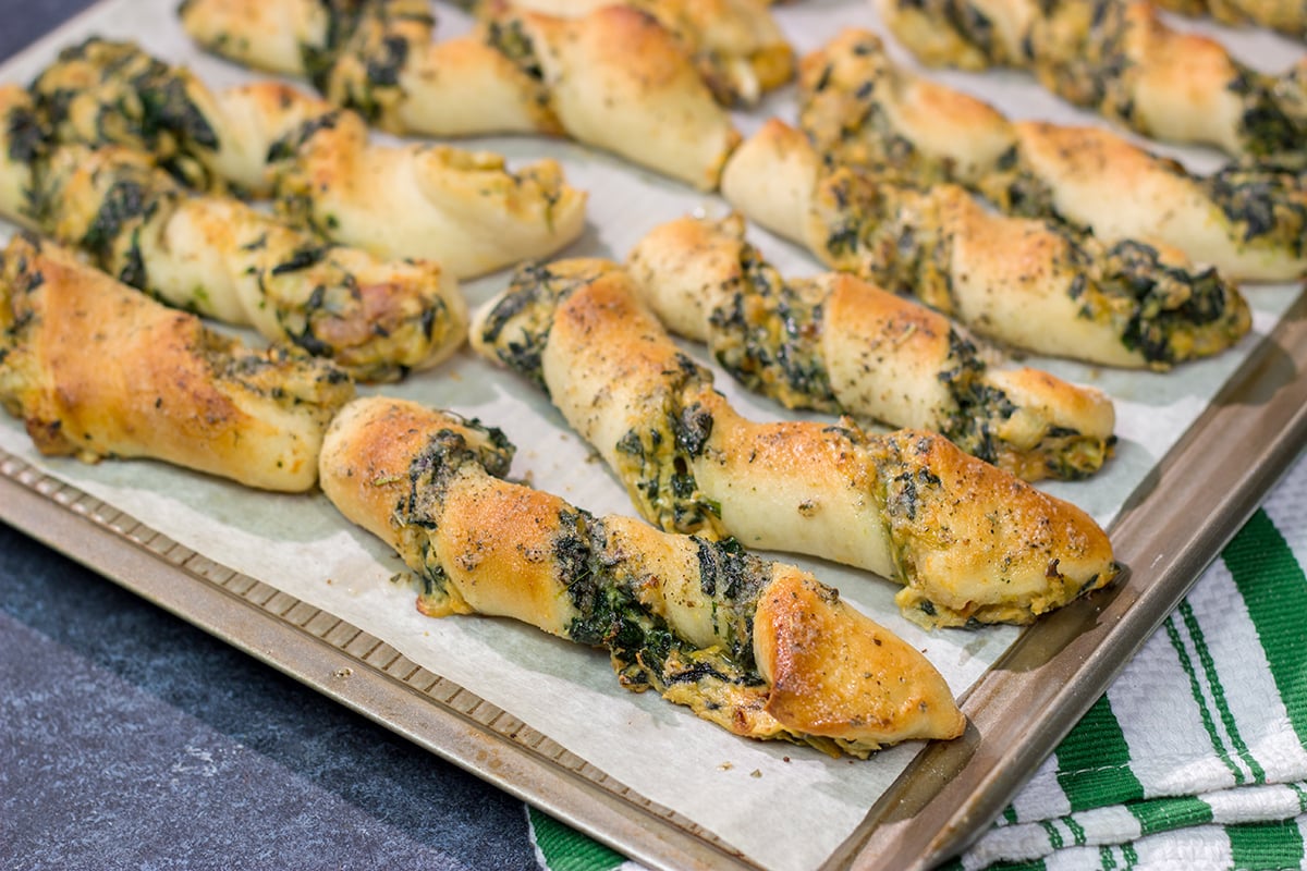 Looking for a tasty gameday appetizer? These Spinach Artichoke Breadsticks are a combination of garlic knots + spinach artichoke dip. They're delicious!
