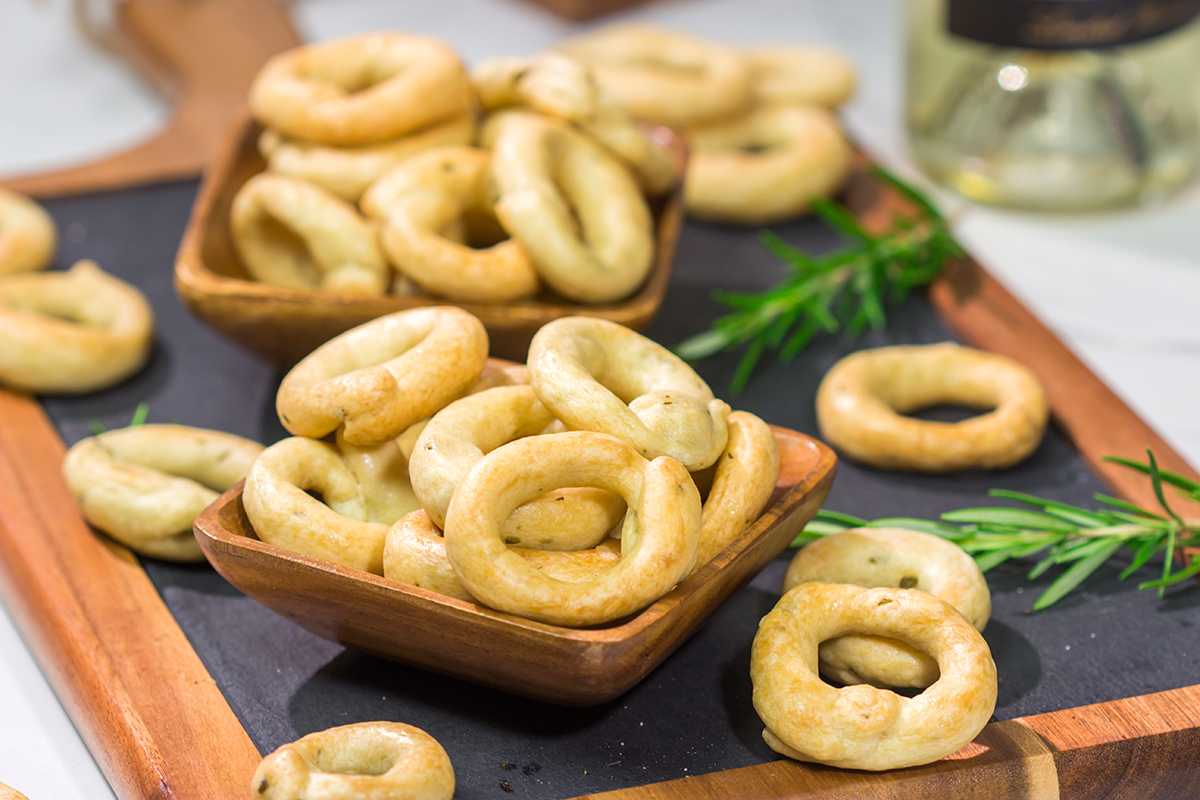 Lightly flavored with olive oil and chopped rosemary, Taralli are the perfect snack to serve alongside a good glass of wine!