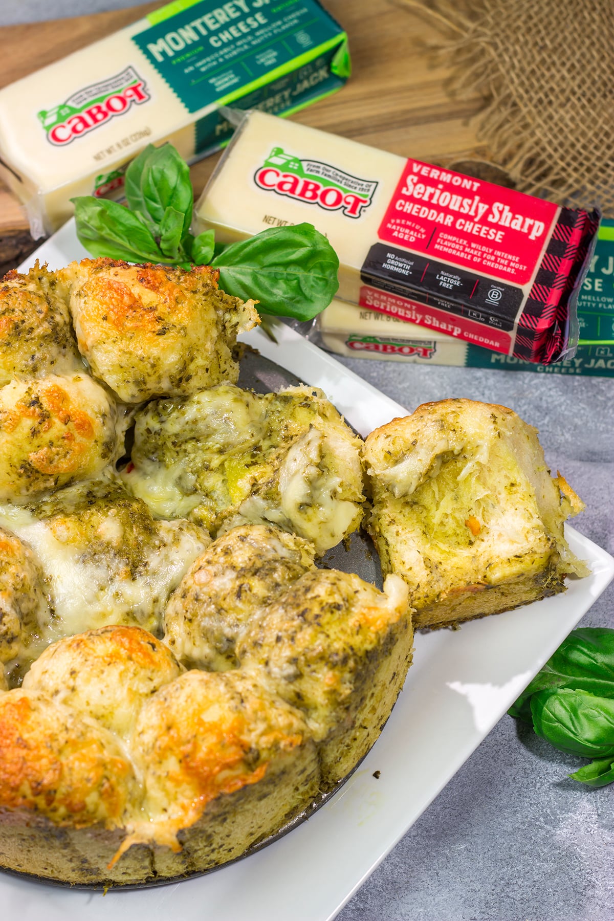 This Cheesy Pesto Pull Apart Bread features freshly baked bread layered with two types of cheese and basil pesto. It's perfect for tailgating or game nights with friends!