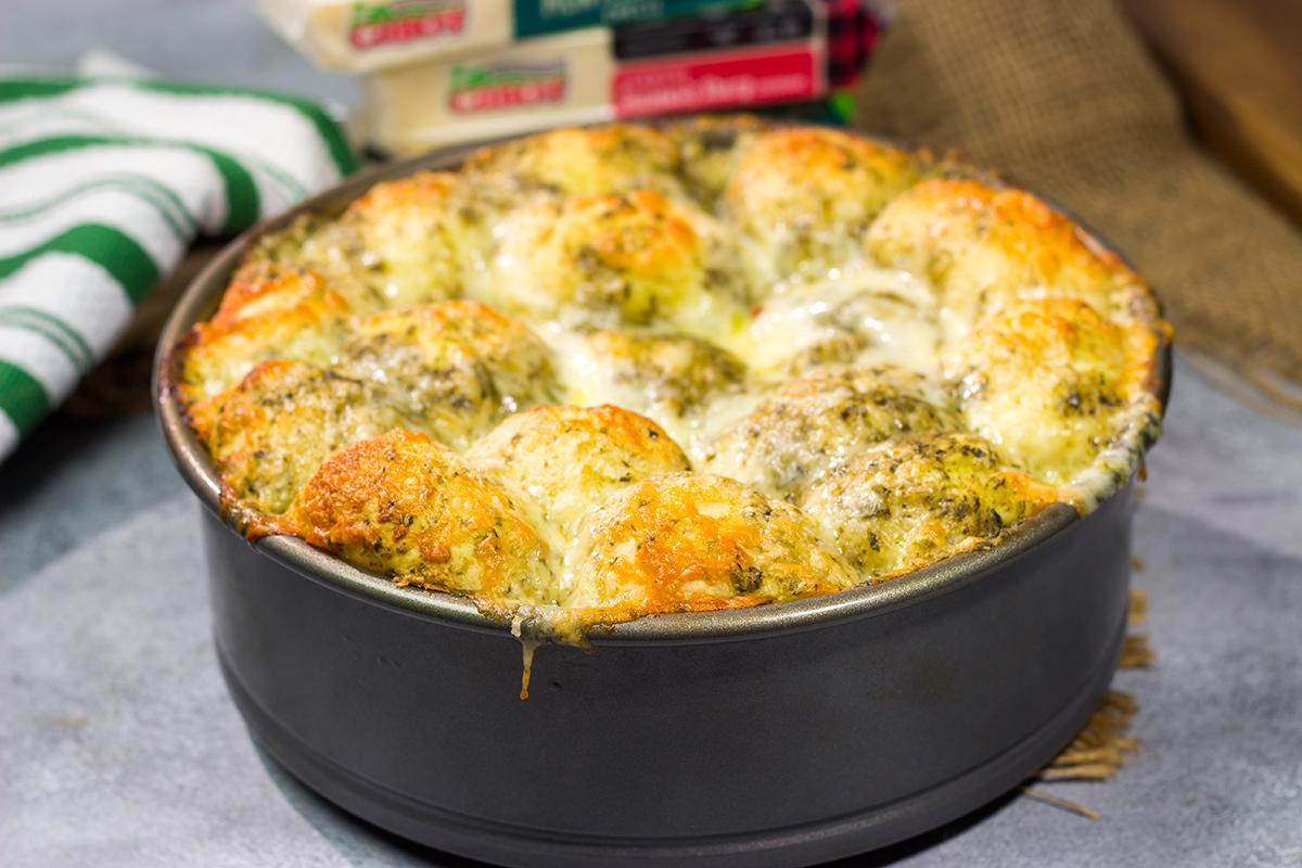 This Cheesy Pesto Pull Apart Bread features freshly baked bread layered with two types of cheese and basil pesto. It's perfect for tailgating or game nights with friends!