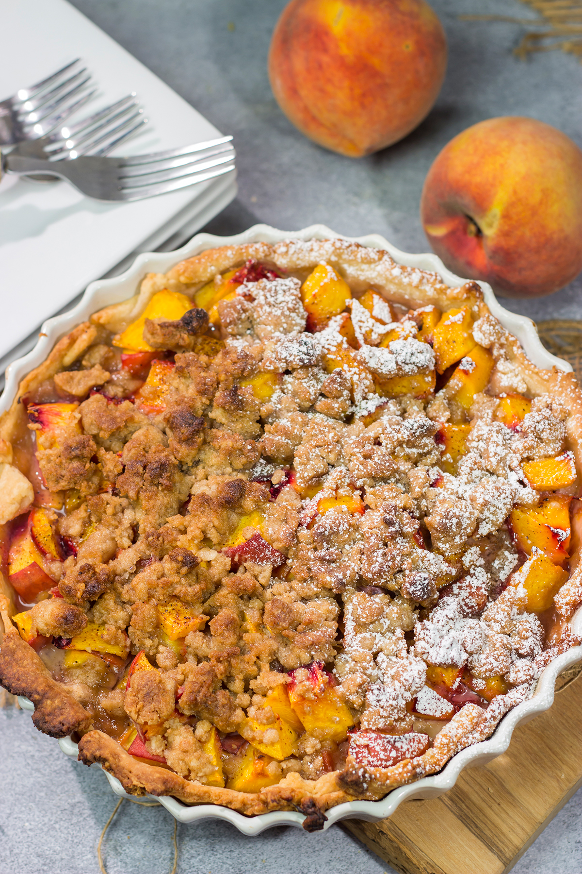 This Peach Crumble Pie features ripe peaches combined with brown sugar and nutmeg. The filling goes on top of a flaky, buttery crust and then a cinnamon sugar crumble gets sprinkled on top. Add a scoop of vanilla ice cream for the perfect summer dessert!