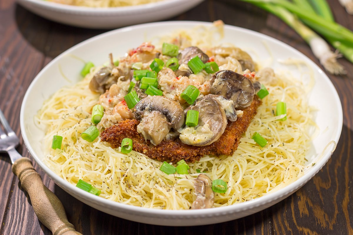 Inspired by the dish from Copeland's of New Orleans, Chicken Rene features garlic butter pasta topped with fried chicken, mushrooms, crab and crawfish. It's delicious!