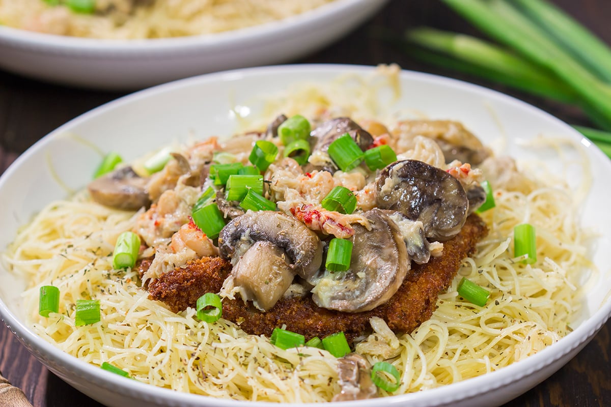 Inspired by the dish from Copeland's of New Orleans, Chicken Rene features garlic butter pasta topped with fried chicken, mushrooms, crab and crawfish. It's delicious!