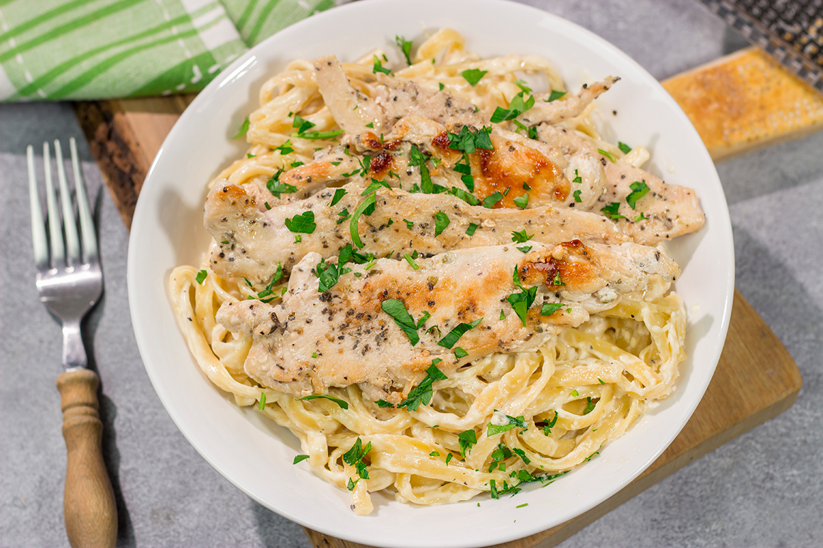Fettuccine Alfredo features fettuccine pasta tossed with a rich, decadent cream sauce. Make a batch of this classic comfort food for dinner tonight!