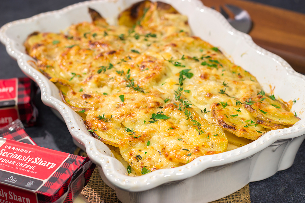 This Cheesy Scalloped Potatoes recipe features layers of potatoes, onions and shredded cheddar cheese. It's a fantastic side dish for dinner!