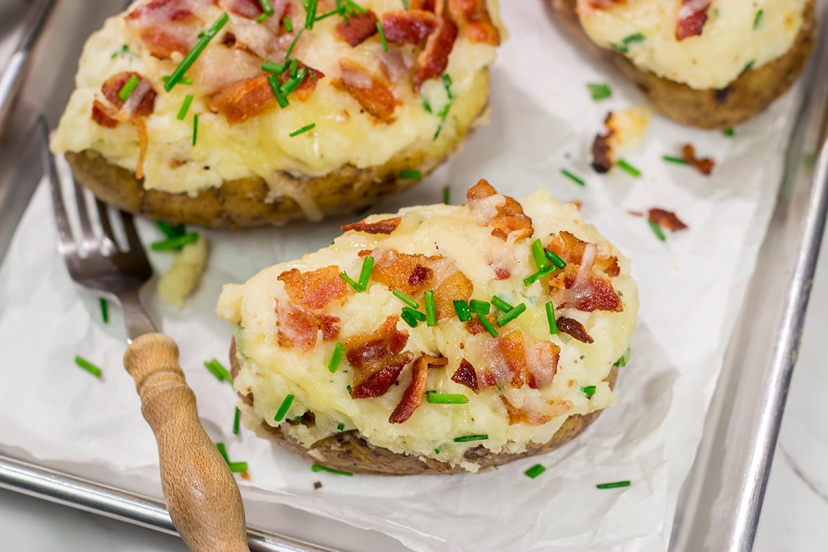 These Grilled Twice-Baked Potatoes feature crispy potato skins filled with creamy mashed potatoes combined with all of your favorite toppings. Add in the grill flavor and you've got one heck of a recipe!