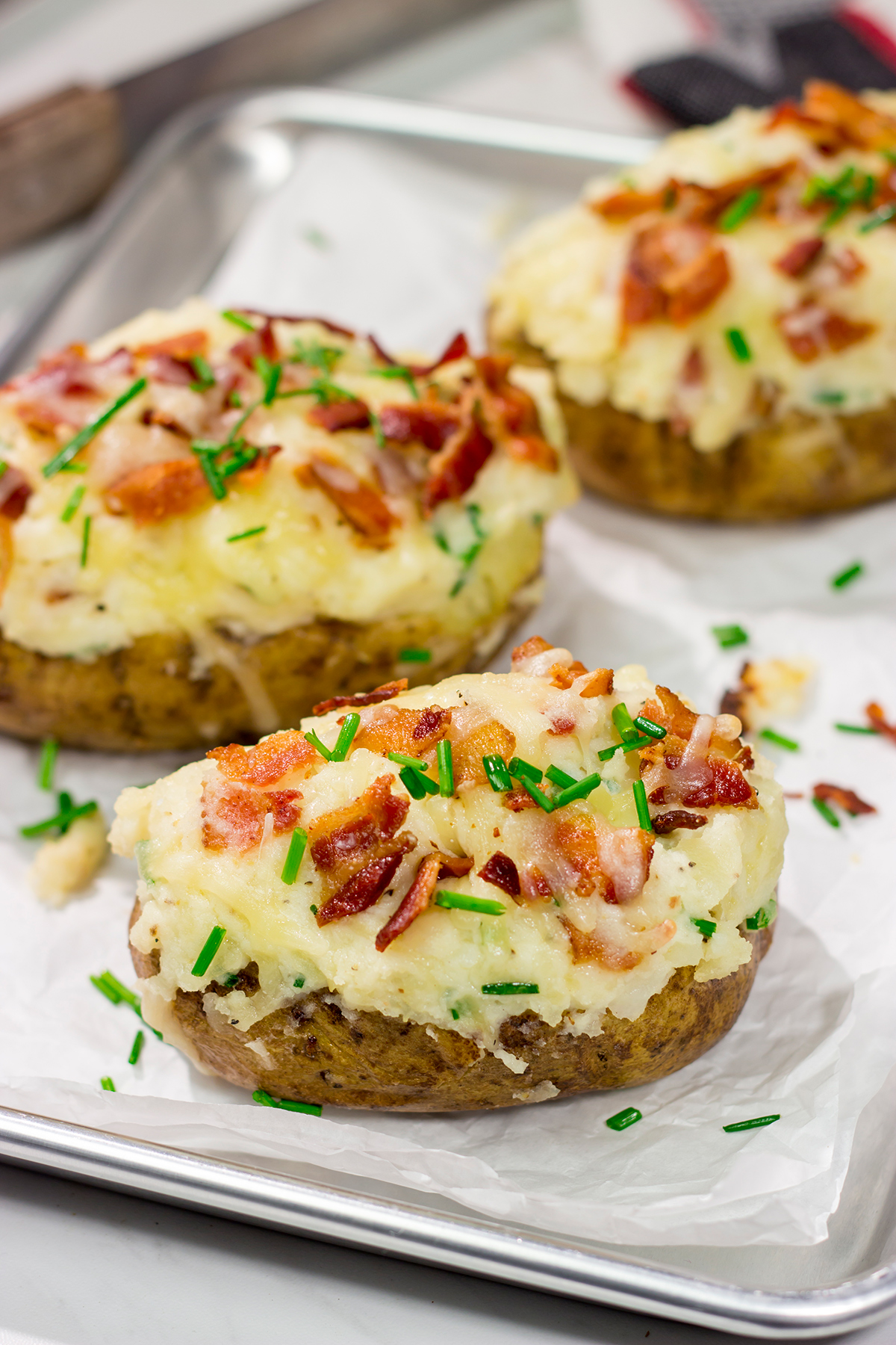 These Grilled Twice-Baked Potatoes feature crispy potato skins filled with creamy mashed potatoes combined with all of your favorite toppings. Add in the grill flavor and you've got one heck of a recipe!