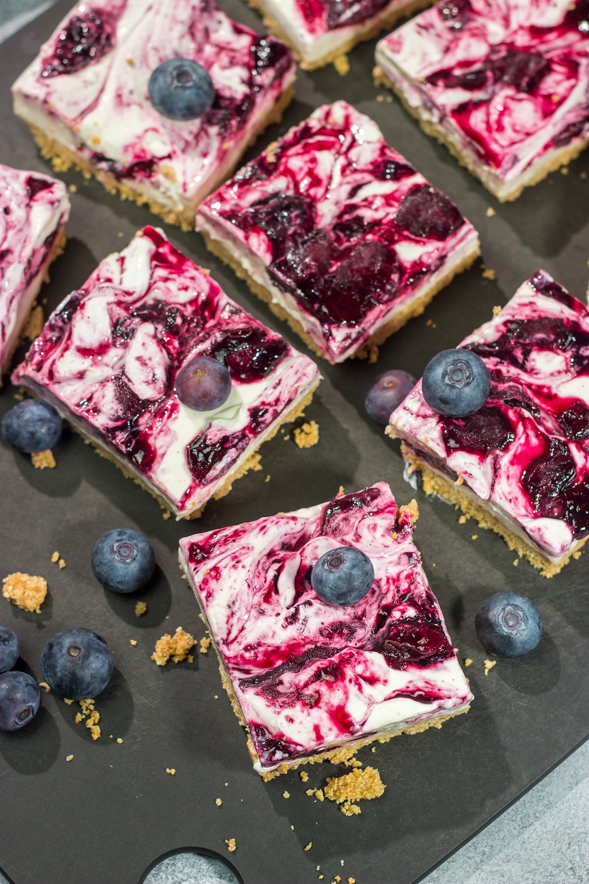 These No Bake Blueberry Cheesecake Bars feature a creamy cheesecake filling swirled with fresh blueberry jam on top of a buttery graham cracker crust. They're perfect for a hot summer day!