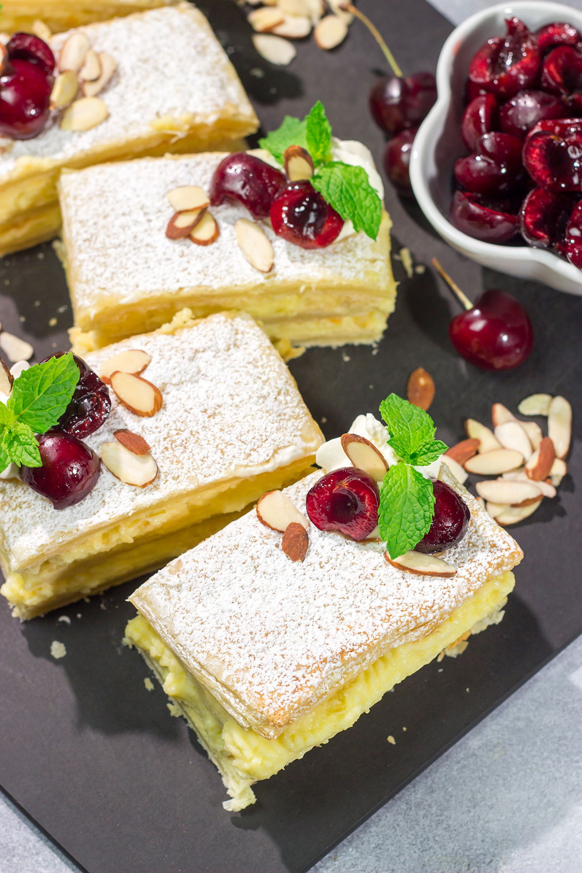Filled with silky almond pastry cream and topped with juicy cherries, this Cherry Almond Napoleon is a fun twist on the classic French dessert!