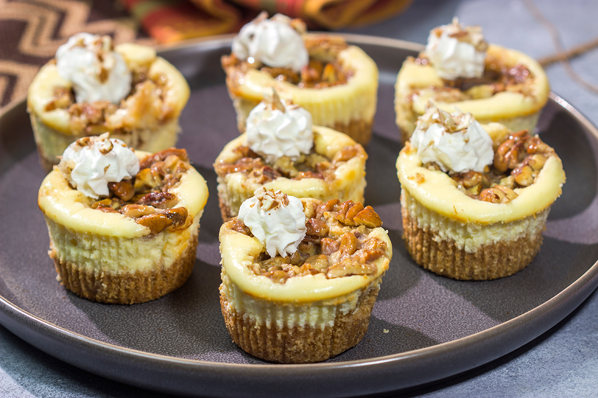 These Mini Pecan Pie Cheesecakes combine creamy cheesecake with crunchy pecan pie topping. This bite-sized dessert is perfect for holiday gatherings!