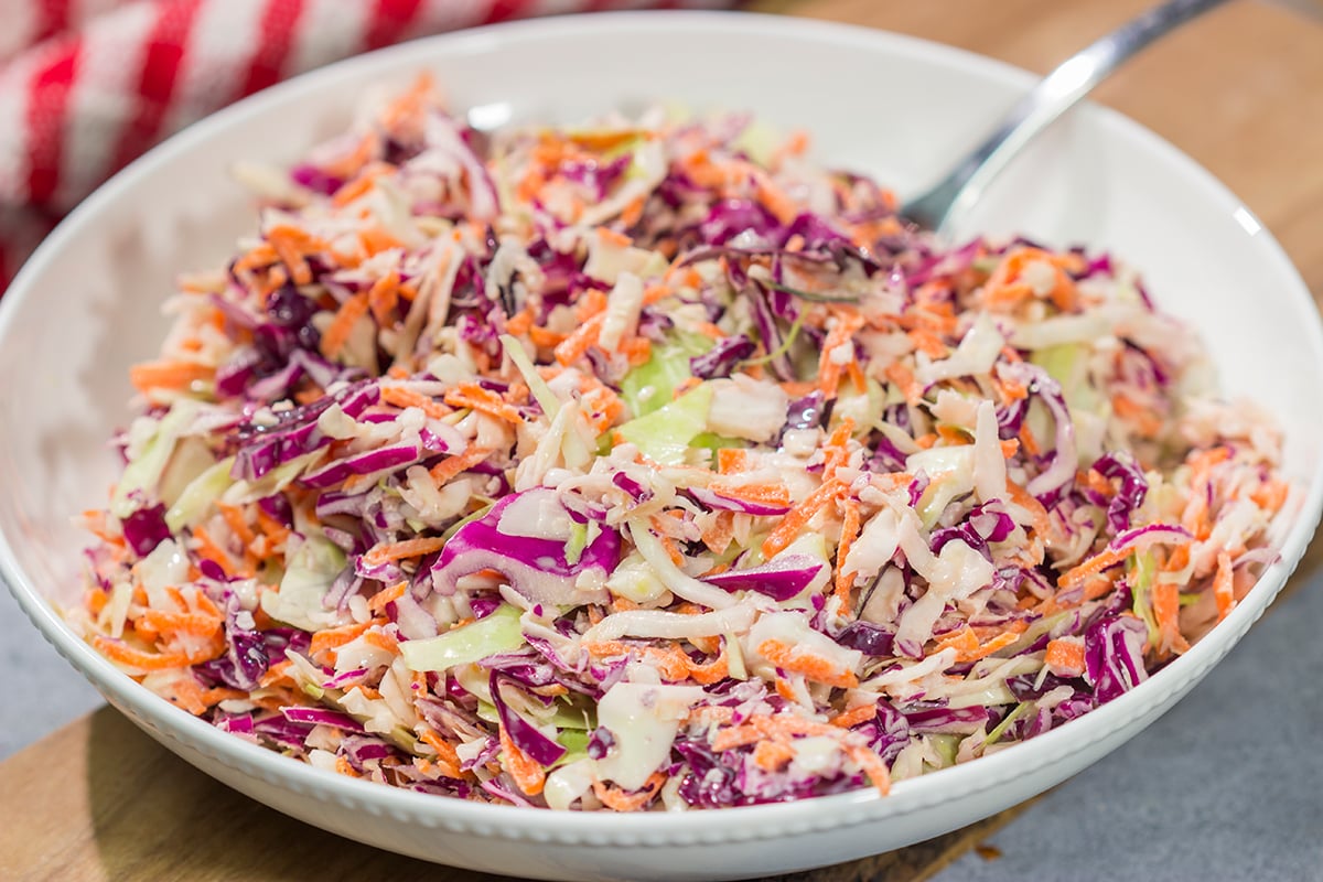 This Easy Coleslaw can be served as either a topping or a side dish. This creamy coleslaw recipe pairs well with barbecue, burgers and fried chicken.