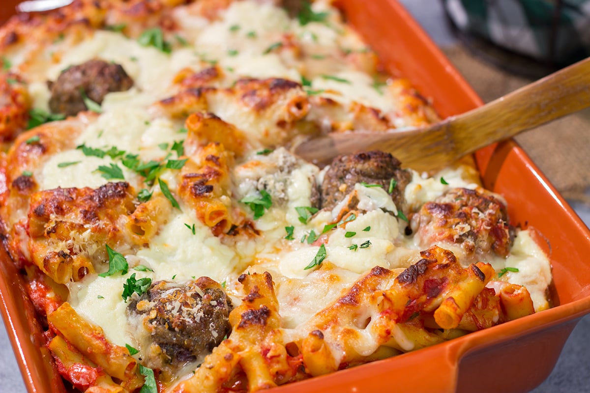 This Baked Ziti with Meatballs recipe is the ultimate comfort food. Pasta, gooey melted cheese and meatballs combine to create a delicious casserole!