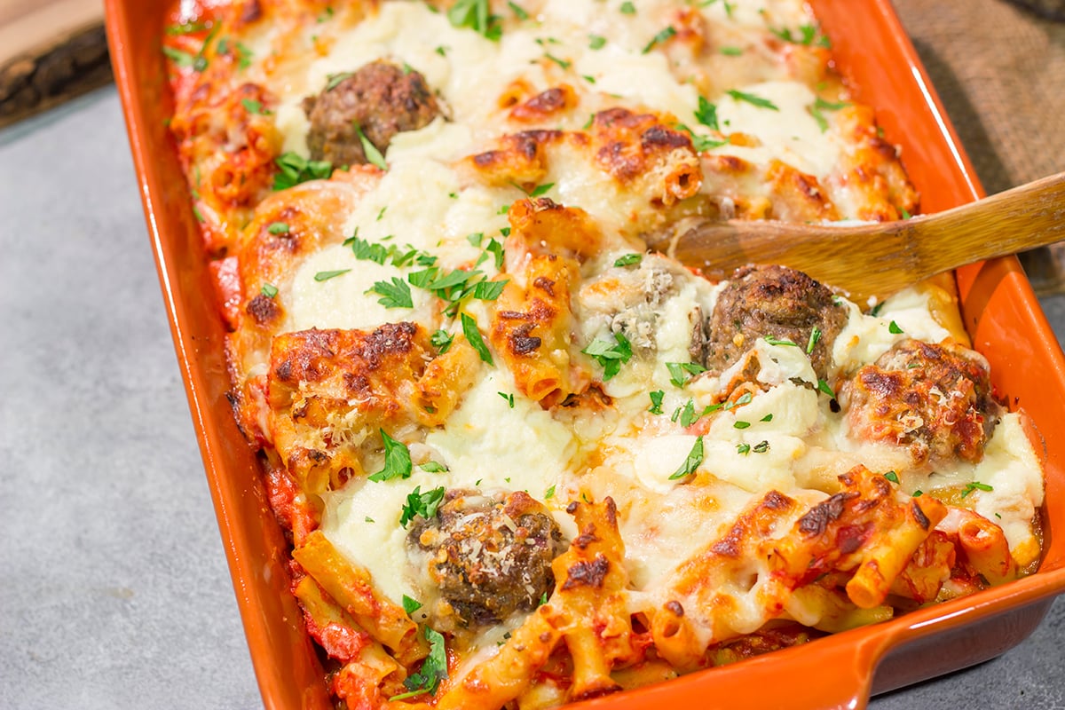 This Baked Ziti with Meatballs recipe is the ultimate comfort food. Pasta, gooey melted cheese and meatballs combine to create a delicious casserole!