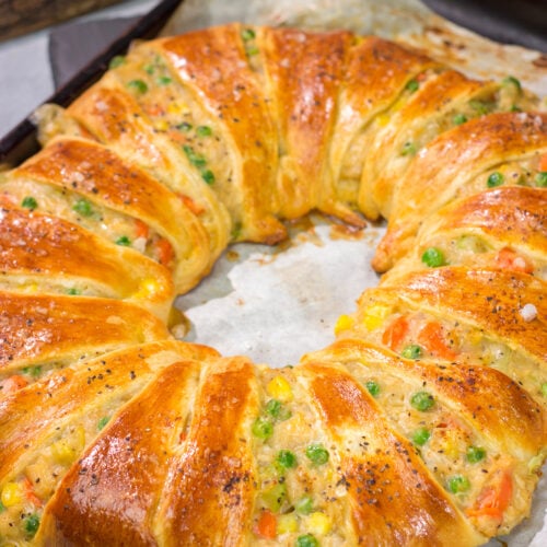 Put a unique spin on dinner with this Chicken Pot Pie Wreath! Homemade pot pie filling is wrapped in flaky crescent dough and shaped into a wreath for a fun take on a classic comfort food meal!