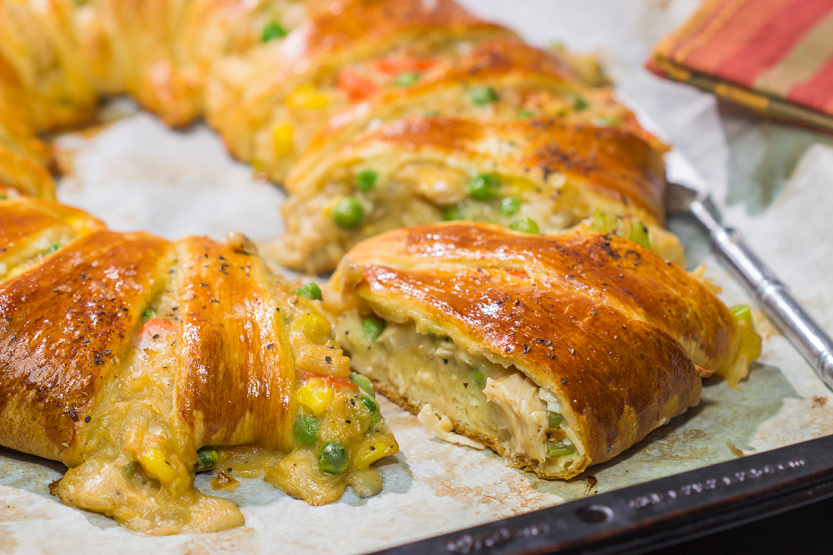 Put a unique spin on dinner with this Chicken Pot Pie Wreath! Homemade pot pie filling is wrapped in flaky crescent dough and shaped into a wreath for a fun take on a classic comfort food meal!