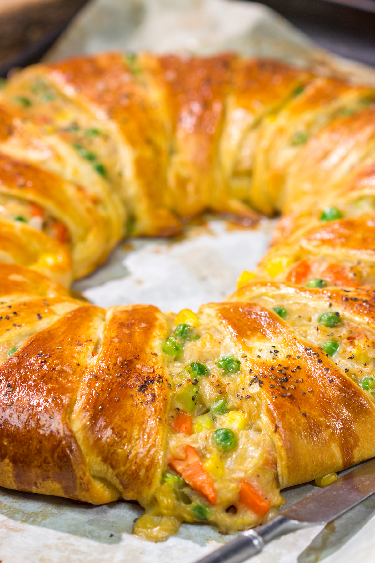 Put a unique spin on dinner with this Chicken Pot Pie Wreath! Homemade pot pie filling is wrapped in flaky crescent dough and shaped into a wreath for a fun take on a classic comfort food meal!