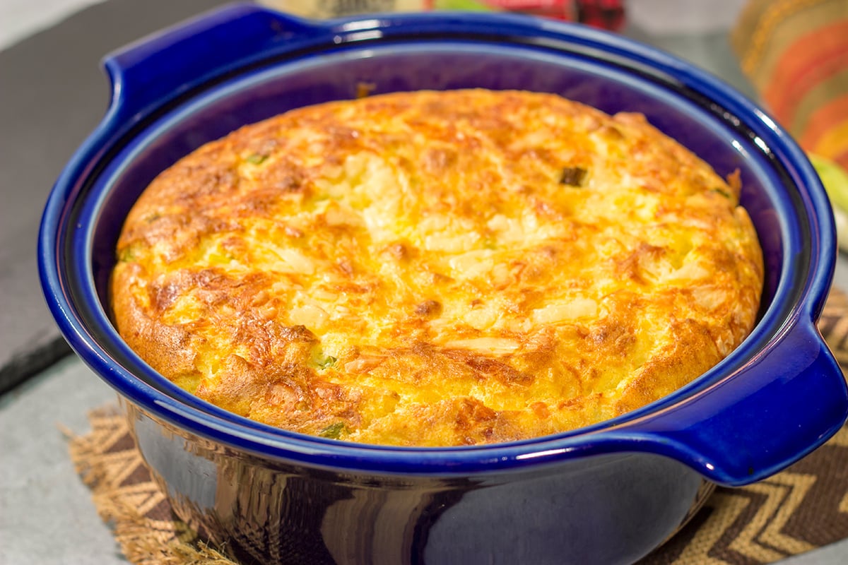 This Cheesy Spoon Bread is a cross between a souffle and cornbread. It's an easy dinner side dish that is packed with cheesy flavor!