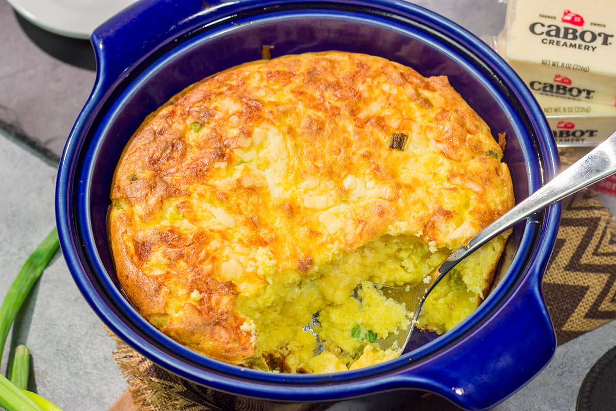 This Cheesy Spoon Bread is a cross between a souffle and cornbread. It's an easy dinner side dish that is packed with cheesy flavor!