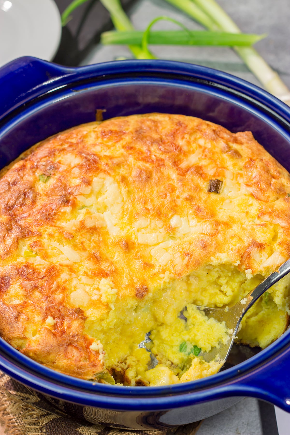 This Cheesy Spoon Bread is a cross between a souffle and cornbread. It's an easy dinner side dish that is packed with cheesy flavor!