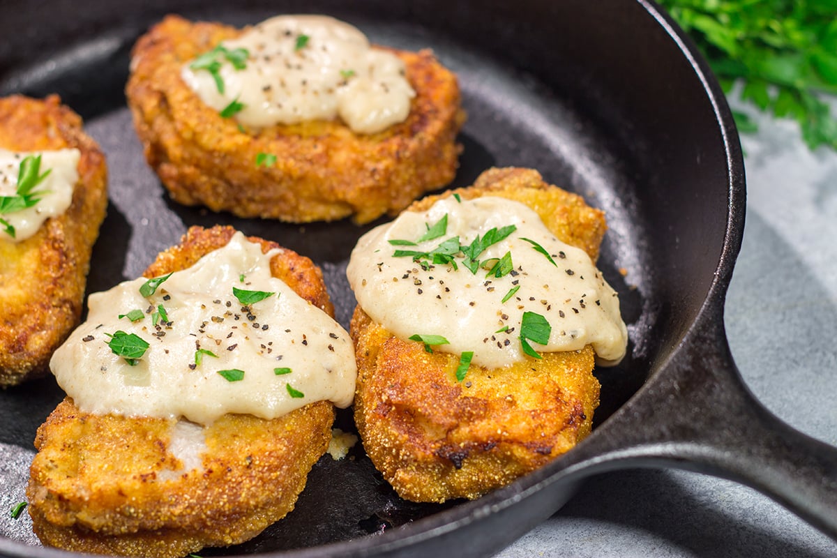 Fried Pork Chops are a classic Southern comfort food! These crispy, tender pork chops are served with an easy homemade gravy on top for maximum flavor.