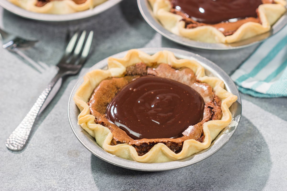 These Mini Fudge Pies are perfect for all chocolate lovers! These pies feature a chocolate chess filling topped with decadent chocolate ganache. Yum!!