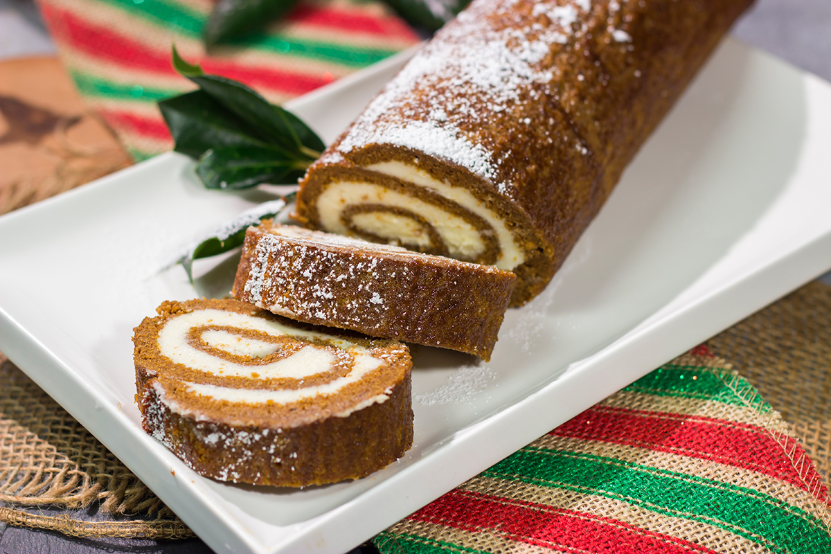 Get into the holiday spirit with this Gingerbread Cake Roll! This festive dessert features a thin gingerbread cake filled with a light and fluffy cream cheese frosting - it's perfect for holiday parties!