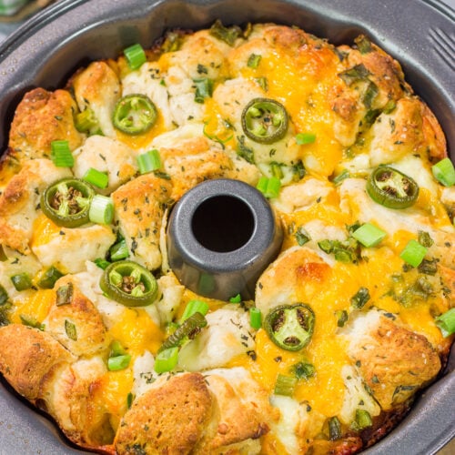 A warm loaf of this Jalapeno Cheddar Monkey Bread will be an instant favorite! This bread combines gooey melted cheese with fresh herbs and diced jalapenos - it's the ultimate comfort food.