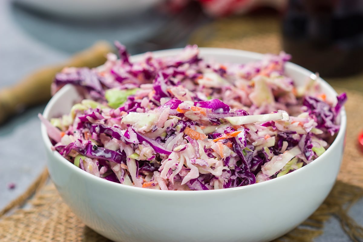 Add a fun twist to a classic coleslaw recipe with this Coca Cola Coleslaw. This classic slaw is flavorful and easy to make. It's perfect for summer picnics and BBQs!