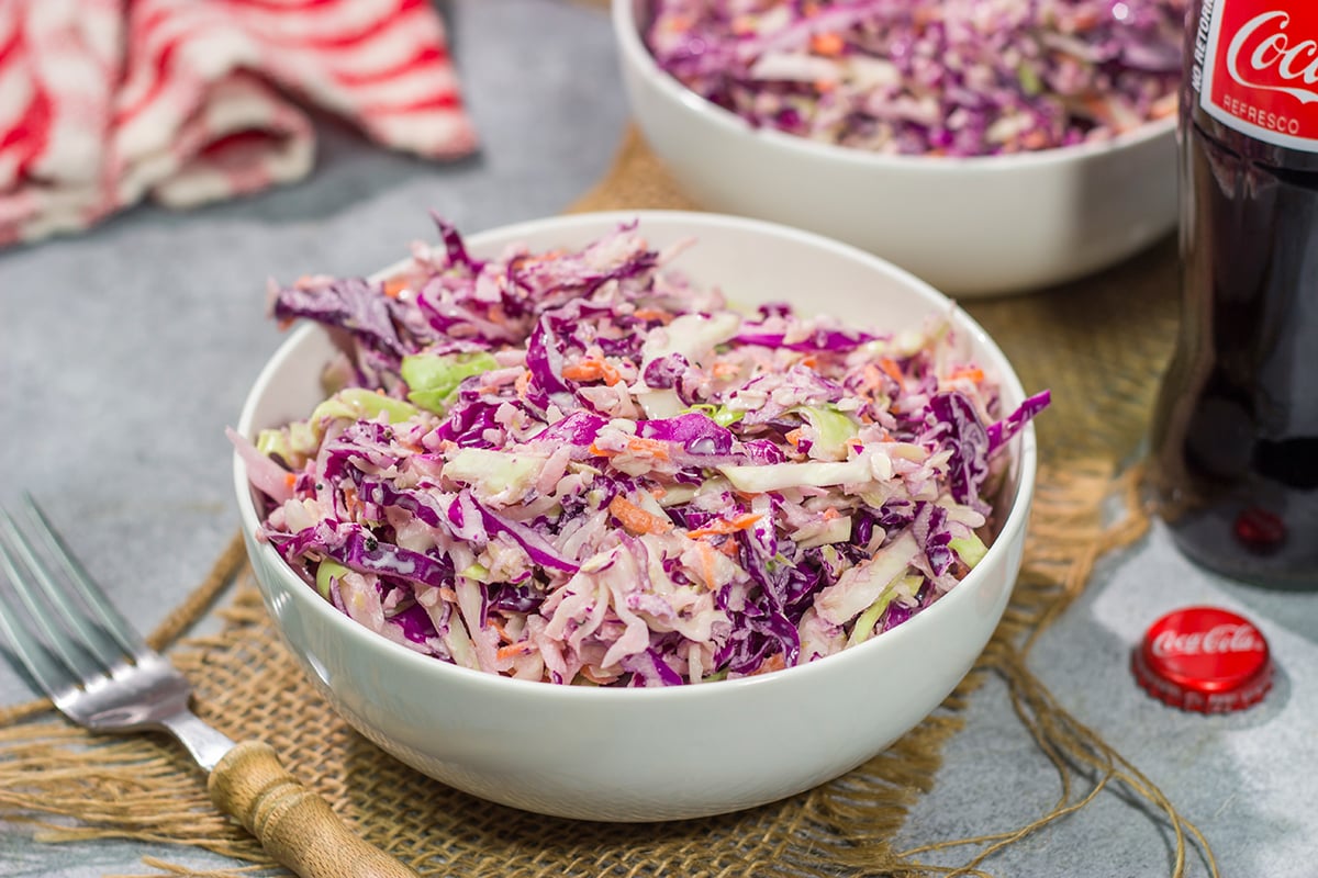 Add a fun twist to a classic coleslaw recipe with this Coca Cola Coleslaw. This classic slaw is flavorful and easy to make. It's perfect for summer picnics and BBQs!