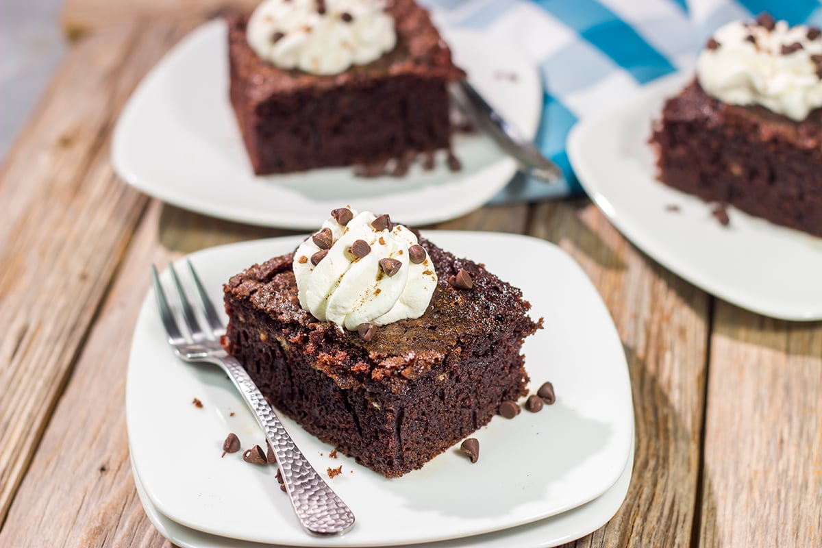 Hot summer day? Skip the oven and bake this Grilled Chocolate Cake on the grill instead! This cake is topped with whipped cream to create a tasty summer dessert.