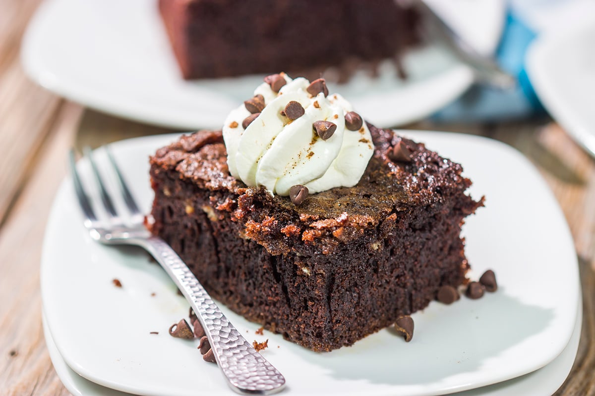 Hot summer day? Skip the oven and bake this Grilled Chocolate Cake on the grill instead! This cake is topped with whipped cream to create a tasty summer dessert.