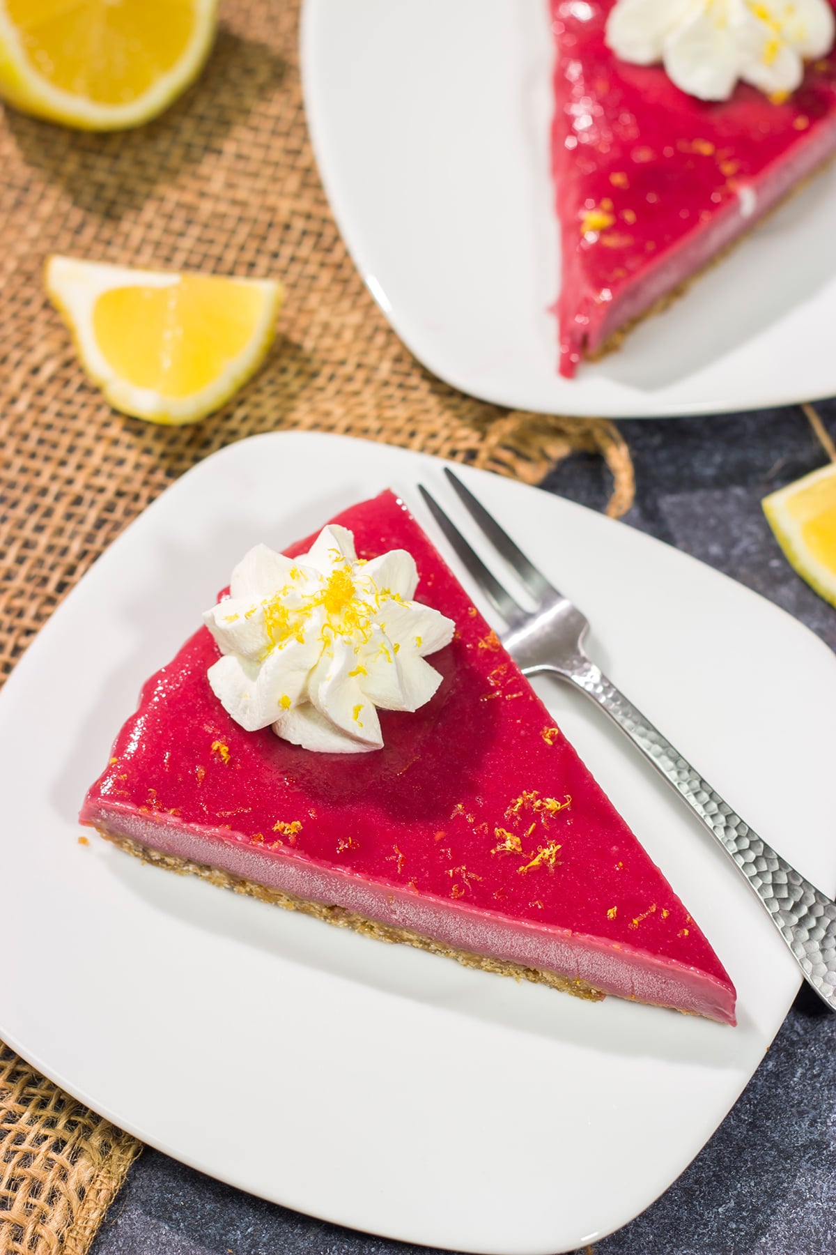 Featuring a sweet + tart raspberry filling over a graham cracker crust, this Frozen Raspberry Lemonade Tart is a tasty dessert for a warm summer evening!