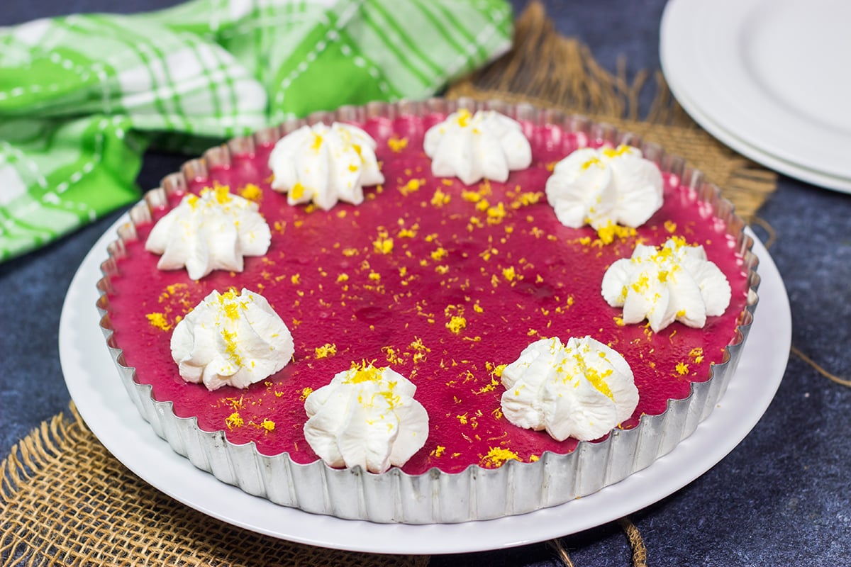 Featuring a sweet + tart raspberry filling over a graham cracker crust, this Frozen Raspberry Lemonade Tart is a tasty dessert for a warm summer evening!