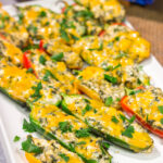These Grilled Spinach Dip Stuffed Jalapenos feature peppers stuffed with creamy homemade spinach dip and topped with cheddar cheese. They're a delicious appetizer for summer grilling!