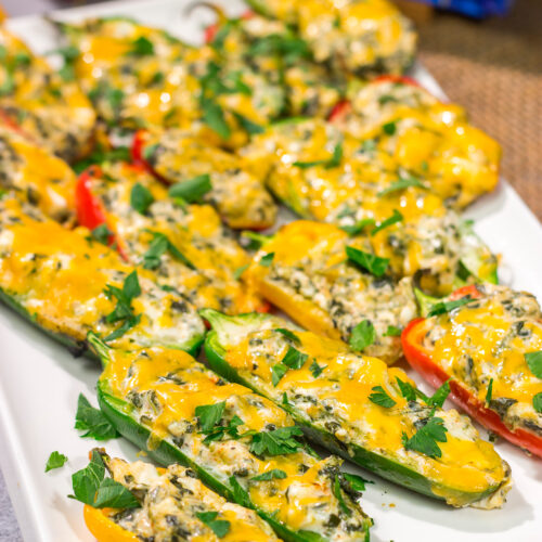 These Grilled Spinach Dip Stuffed Jalapenos feature peppers stuffed with creamy homemade spinach dip and topped with cheddar cheese. They're a delicious appetizer for summer grilling!