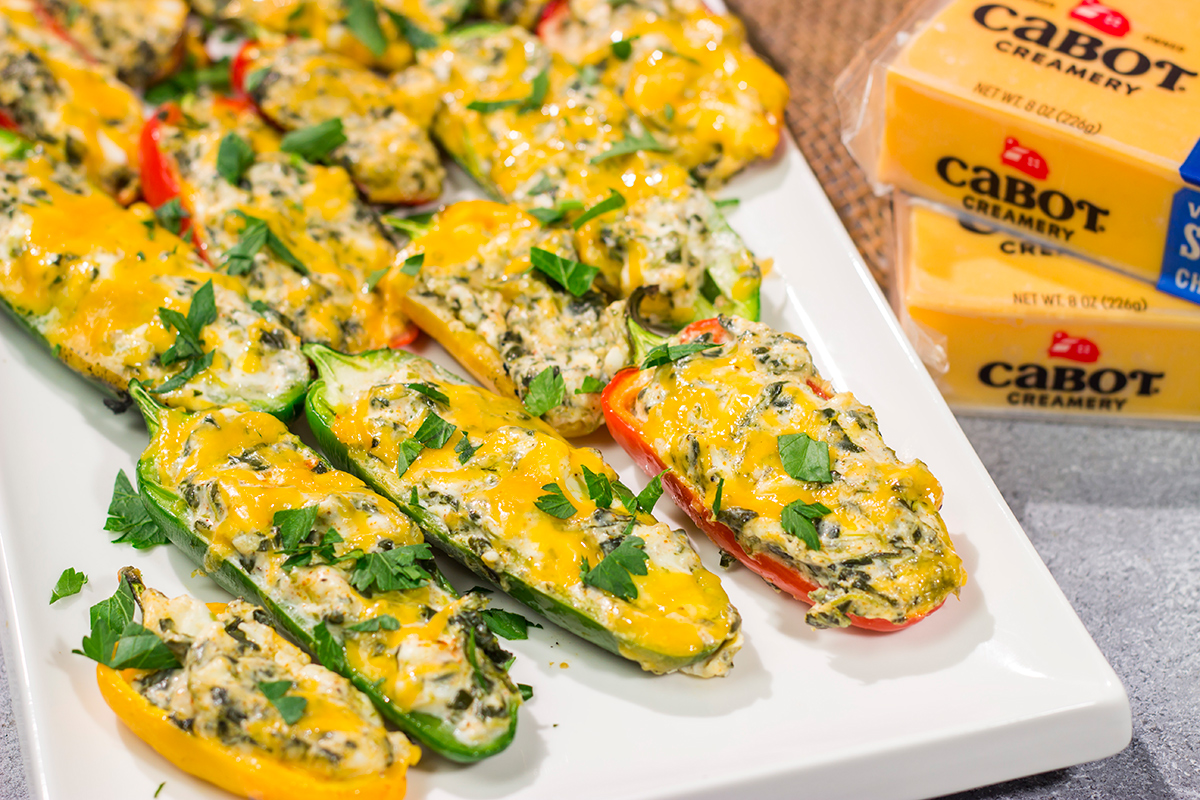 These Grilled Spinach Dip Stuffed Jalapenos feature peppers stuffed with creamy homemade spinach dip and topped with cheddar cheese. They're a delicious appetizer for summer grilling!