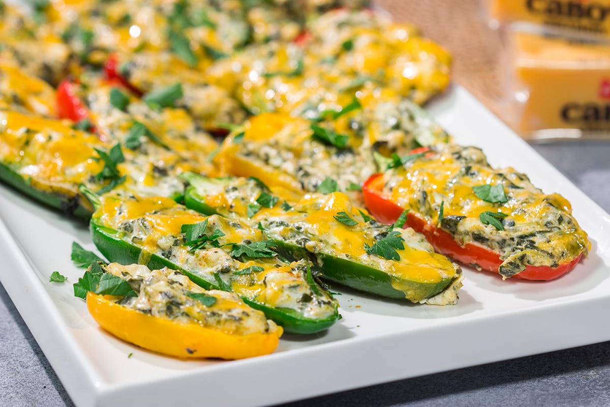 These Grilled Spinach Dip Stuffed Jalapenos feature peppers stuffed with creamy homemade spinach dip and topped with cheddar cheese. They're a delicious appetizer for summer grilling!