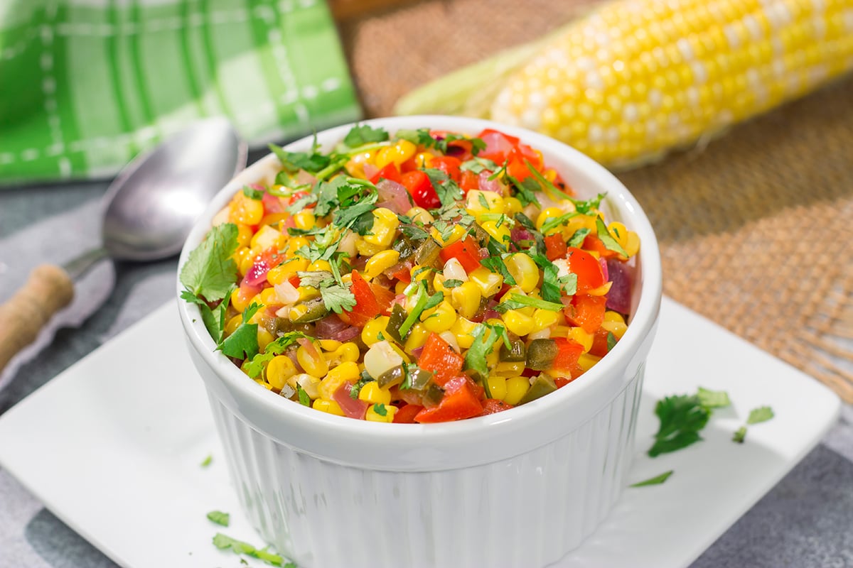 Featuring sweet corn and bell peppers combined with spicy jalapenos and tossed in lime butter, this Mexicali Corn recipe is a tasty side dish for summer meals!