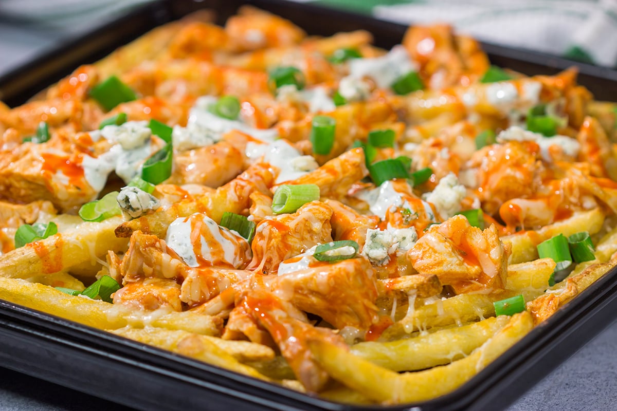 These Buffalo Chicken Cheese Fries are a fantastic gameday appetizer! The kick from the buffalo chicken combined with the creamy blue cheese dressing and melted cheese is a mouthwatering combo.