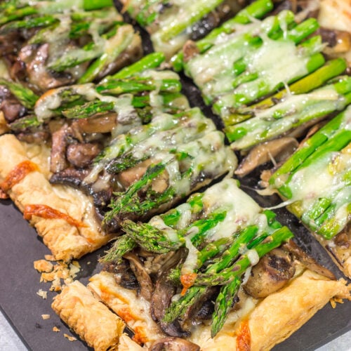 This Cheesy Mushroom Asparagus Tart features flaky puff pastry piled with savory mushrooms, tender asparagus and plenty of melted cheese. It's an easy yet elegant recipe that's perfect for an appetizer or side dish!