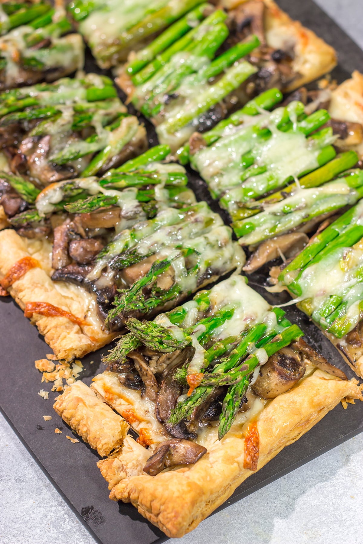 This Cheesy Mushroom Asparagus Tart features flaky puff pastry piled with savory mushrooms, tender asparagus and plenty of melted cheese. It's an easy yet elegant recipe that's perfect for an appetizer or side dish!