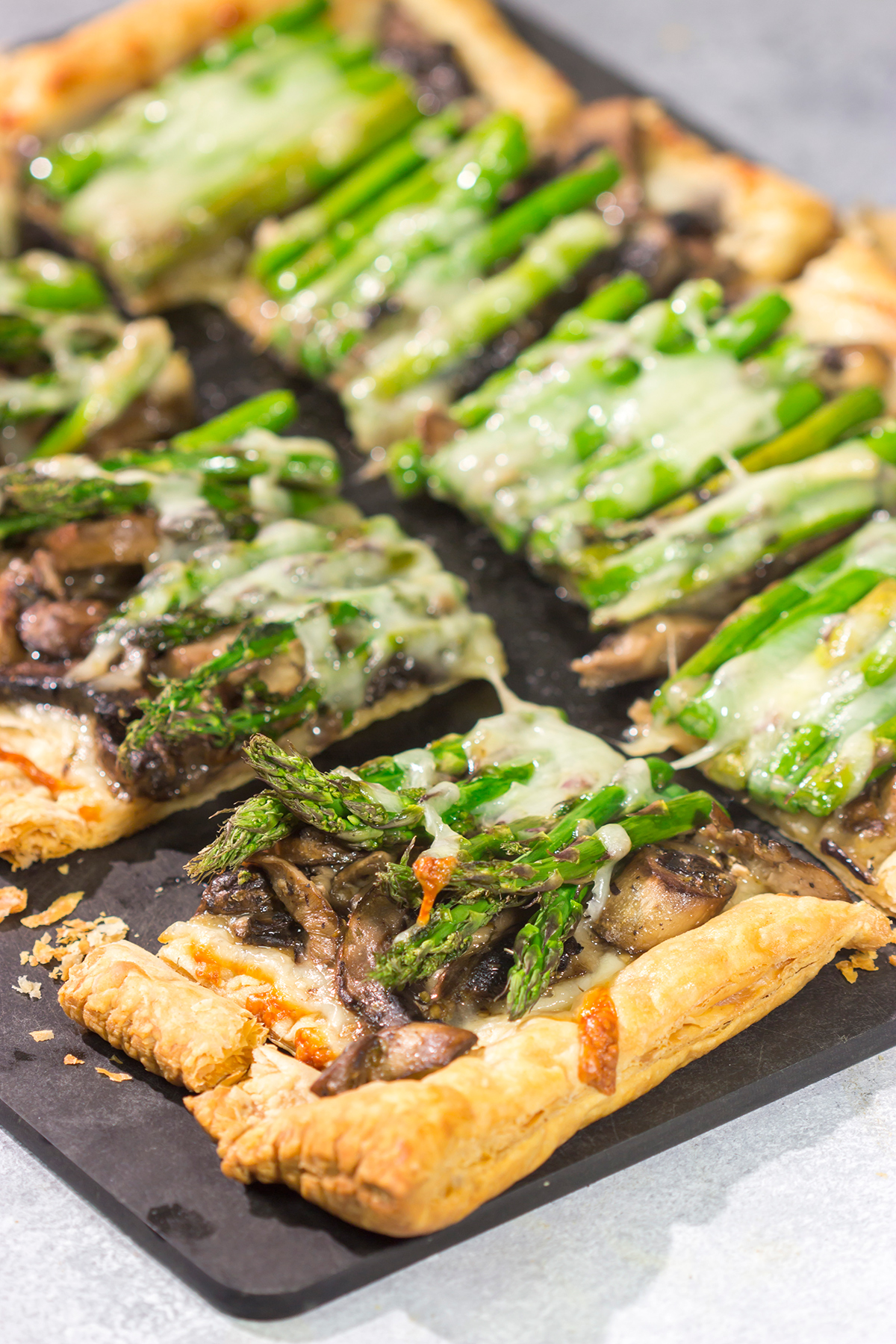 This Cheesy Mushroom Asparagus Tart features flaky puff pastry piled with savory mushrooms, tender asparagus and plenty of melted cheese. It's an easy yet elegant recipe that's perfect for an appetizer or side dish!